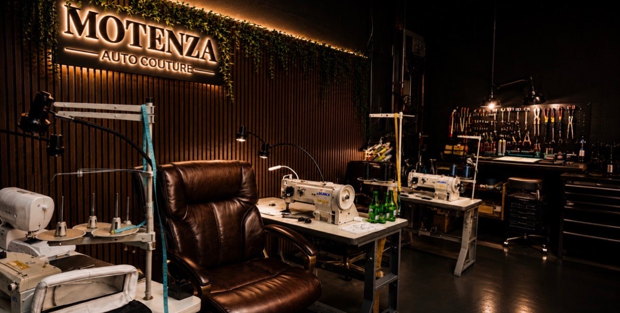 Motenza Auto Couture workshop interior with illuminated signage and upholstery sewing machines
